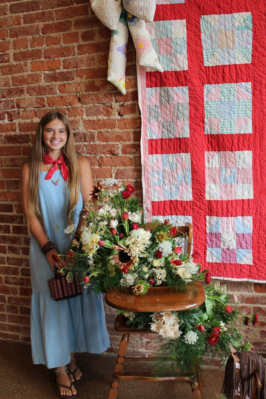 Ria standing beside one of her arrangements at a market stand