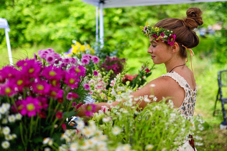 Ria at a flower stall, arranging bright pink and white blooms